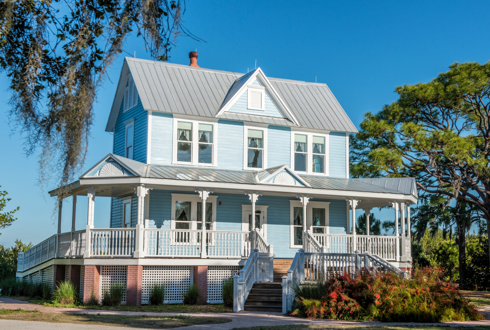 Picture of a two-story house with a grey metal roof installed on it.