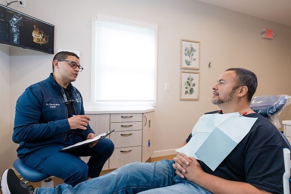 Dr. Gabr talking to a patient who is laying in the dentist's chair
