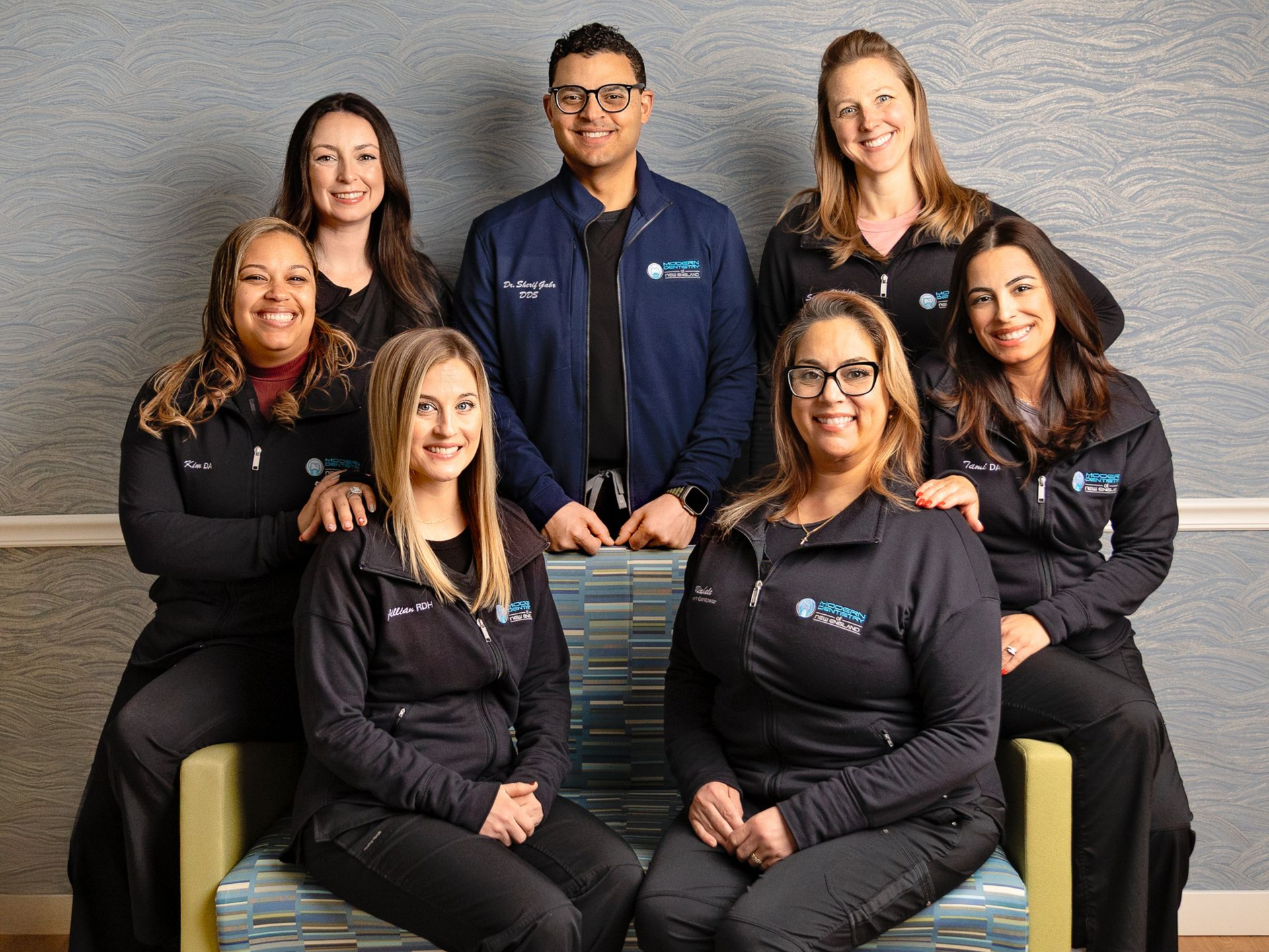 A group of people are posing for a picture in a dental office.