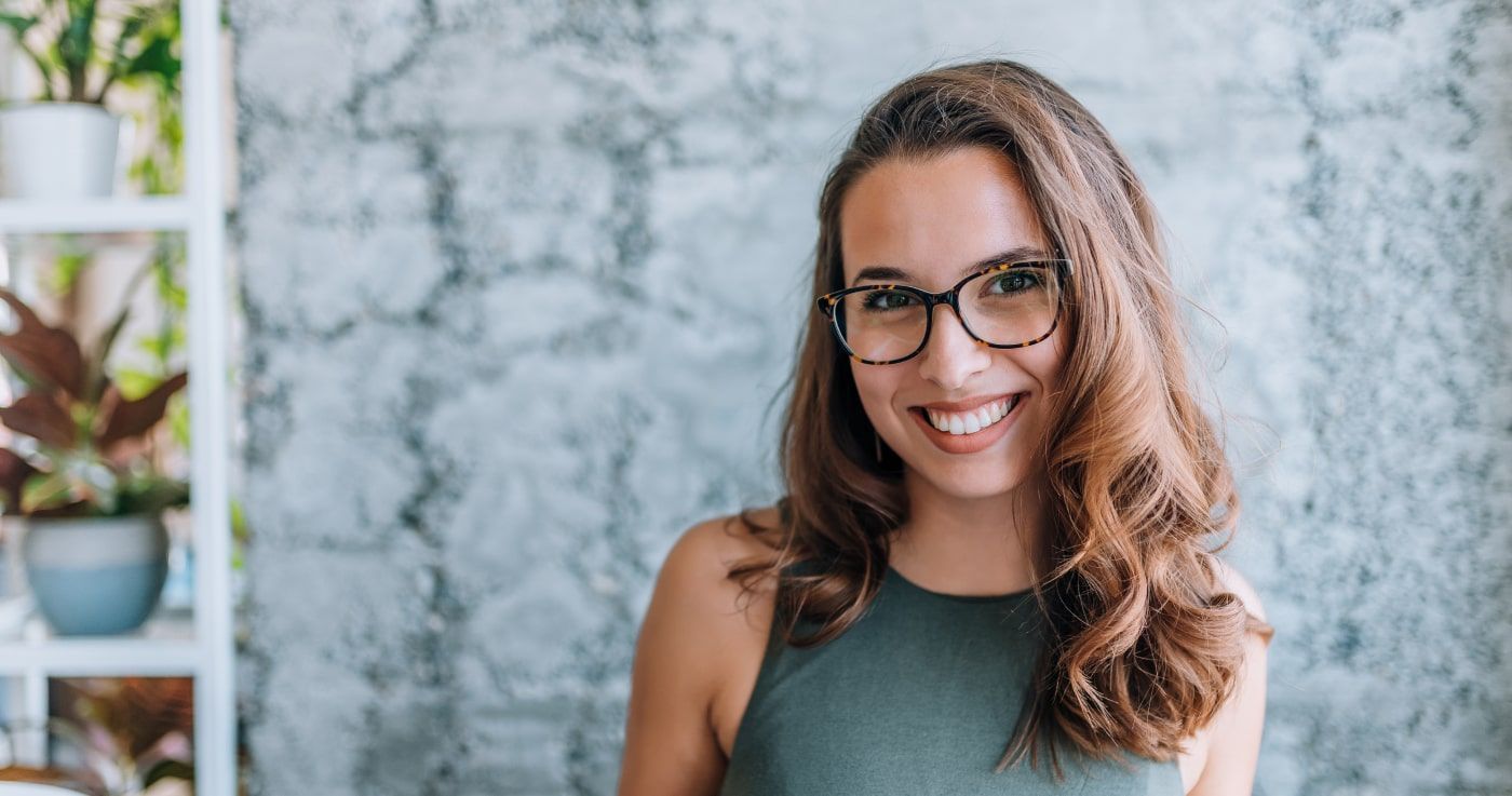 Dental Implants with Modern Dentistry of New England Woman in glasses smiling