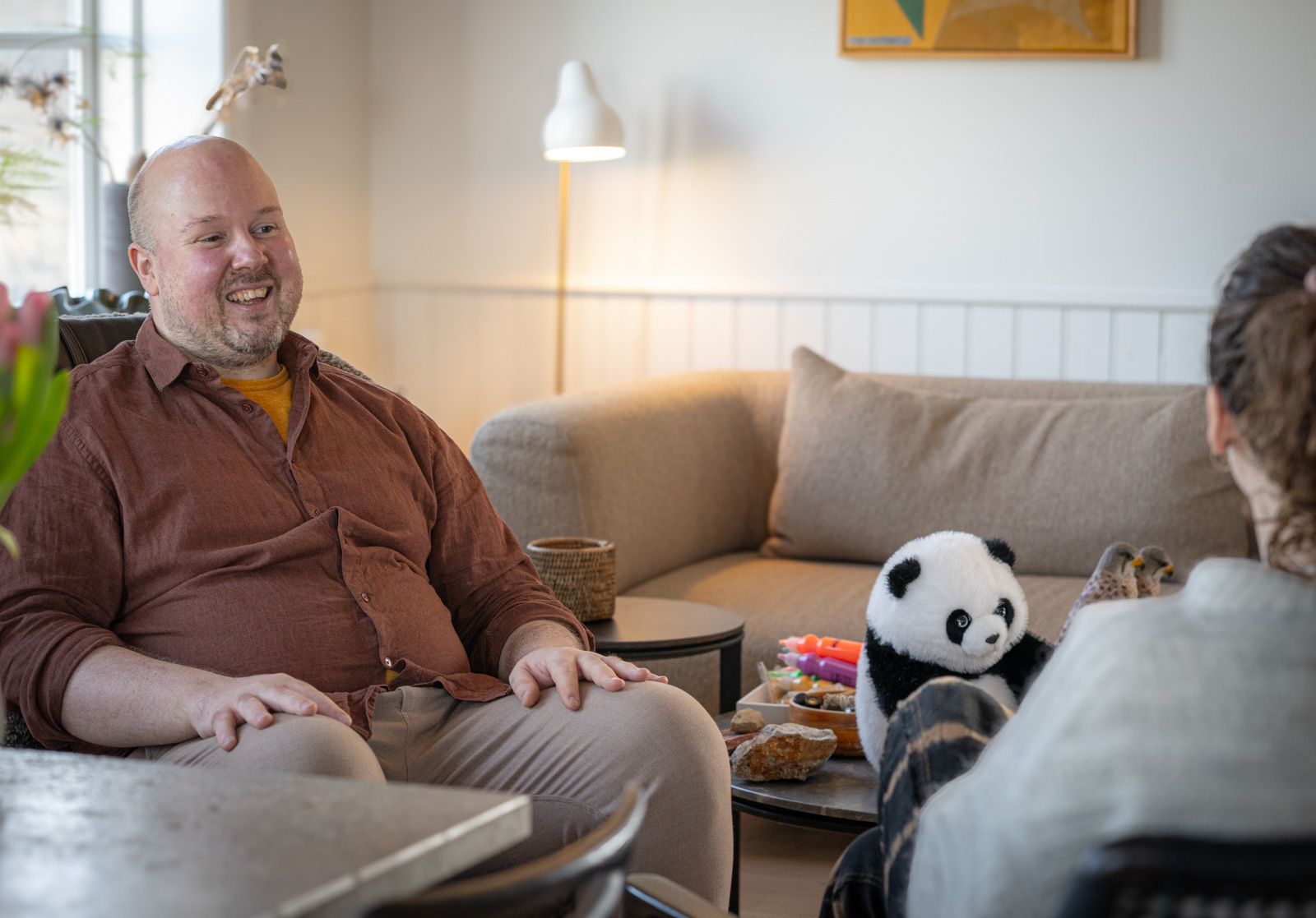 A man and a woman are sitting on a couch in a living room.