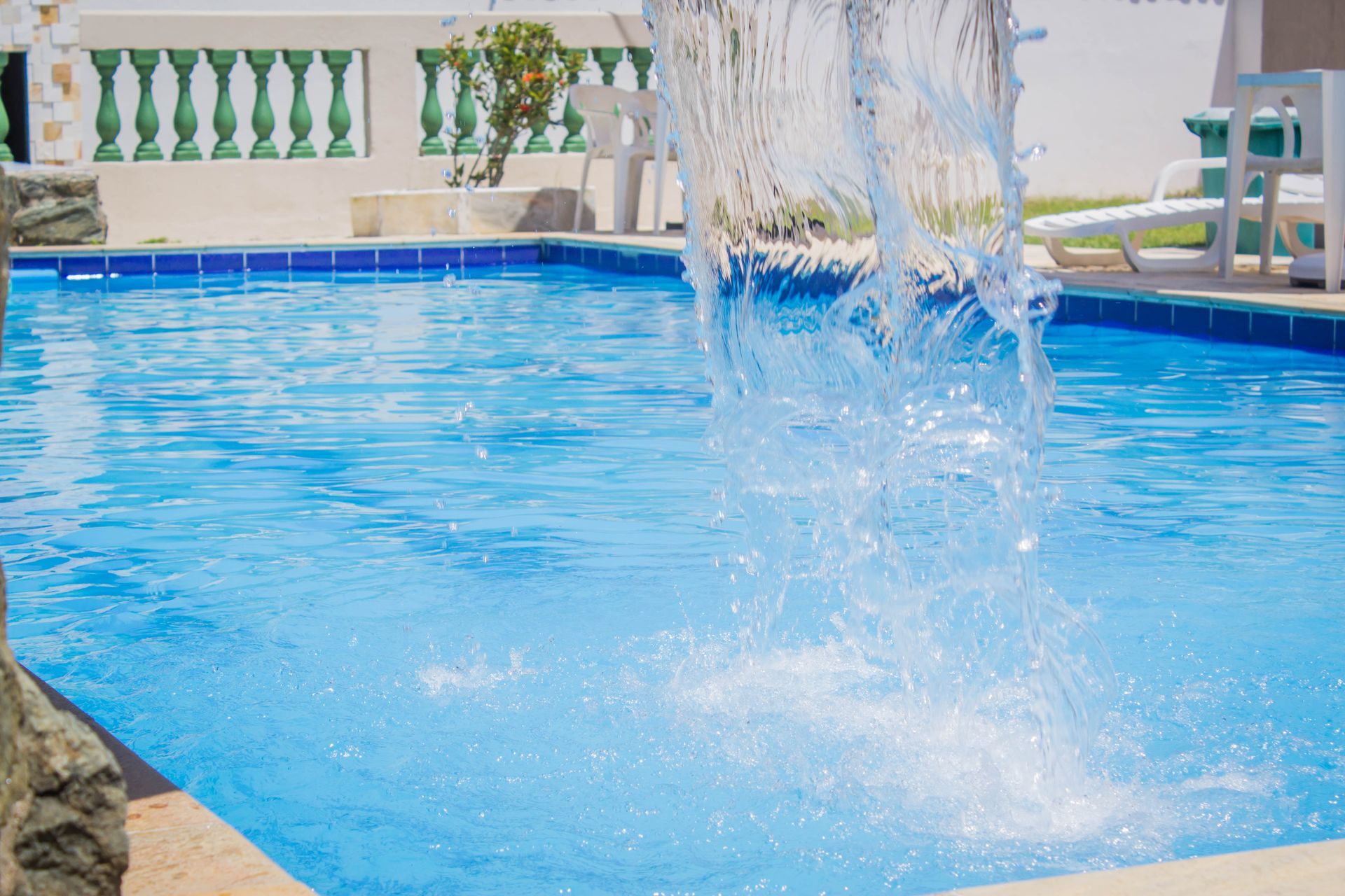 Piscina com fonte. Água azul, dia ensolarado.