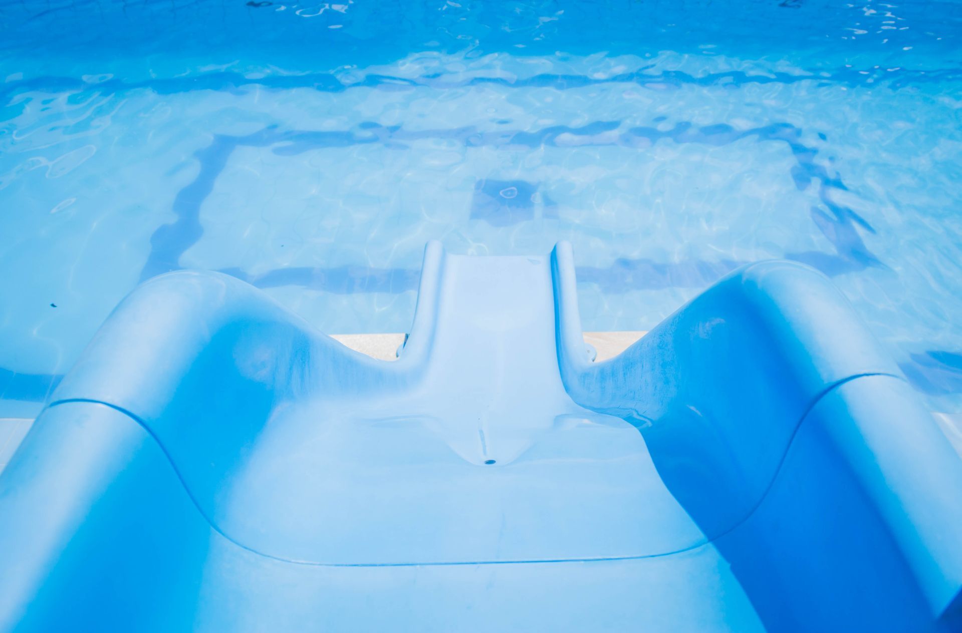 Toboágua azul que leva a uma piscina azul brilhante.