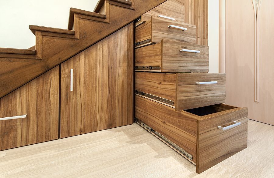 Wooden staircase with built-in storage drawers and cabinets, utilizing space beneath the steps.