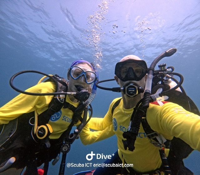 A man is swimming underwater in a swimming pool.