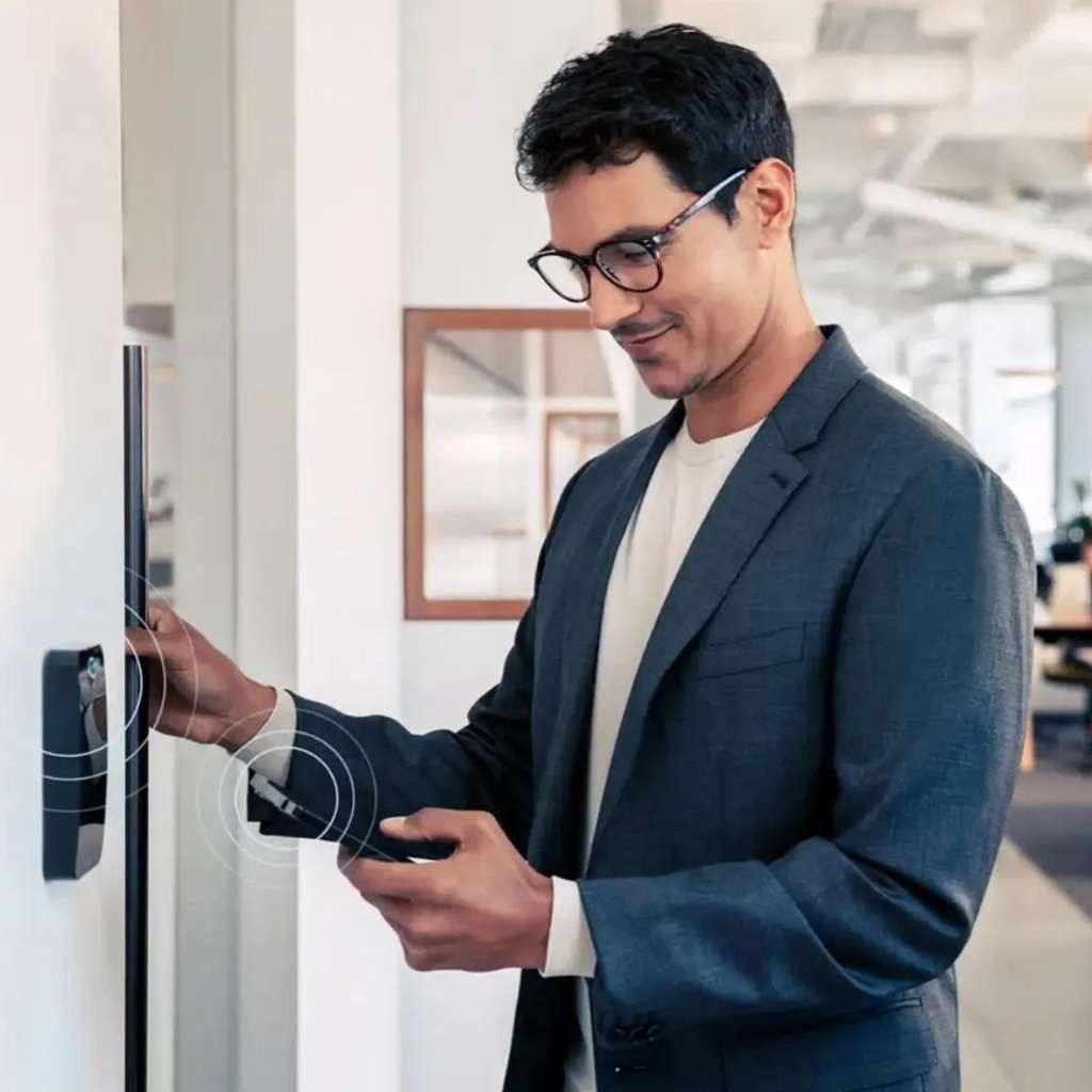 Hand inserting a key into a door lock with a house-shaped keychain