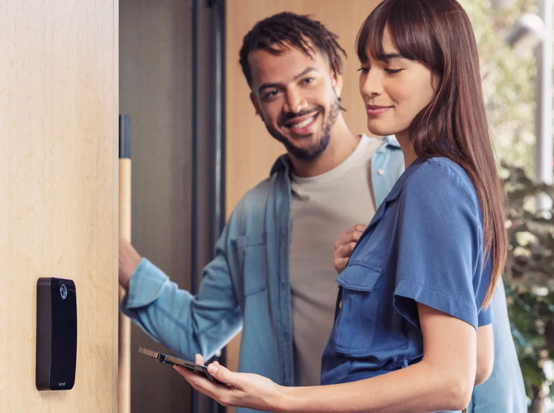 Hands use a key to unlock a door latch and handle.