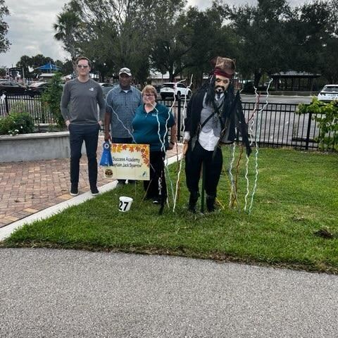 A group of people are standing in the grass holding signs.