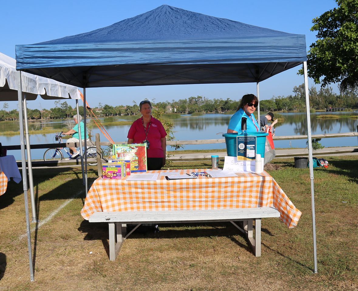 A table with an orange and white checkered tablecloth under a tent