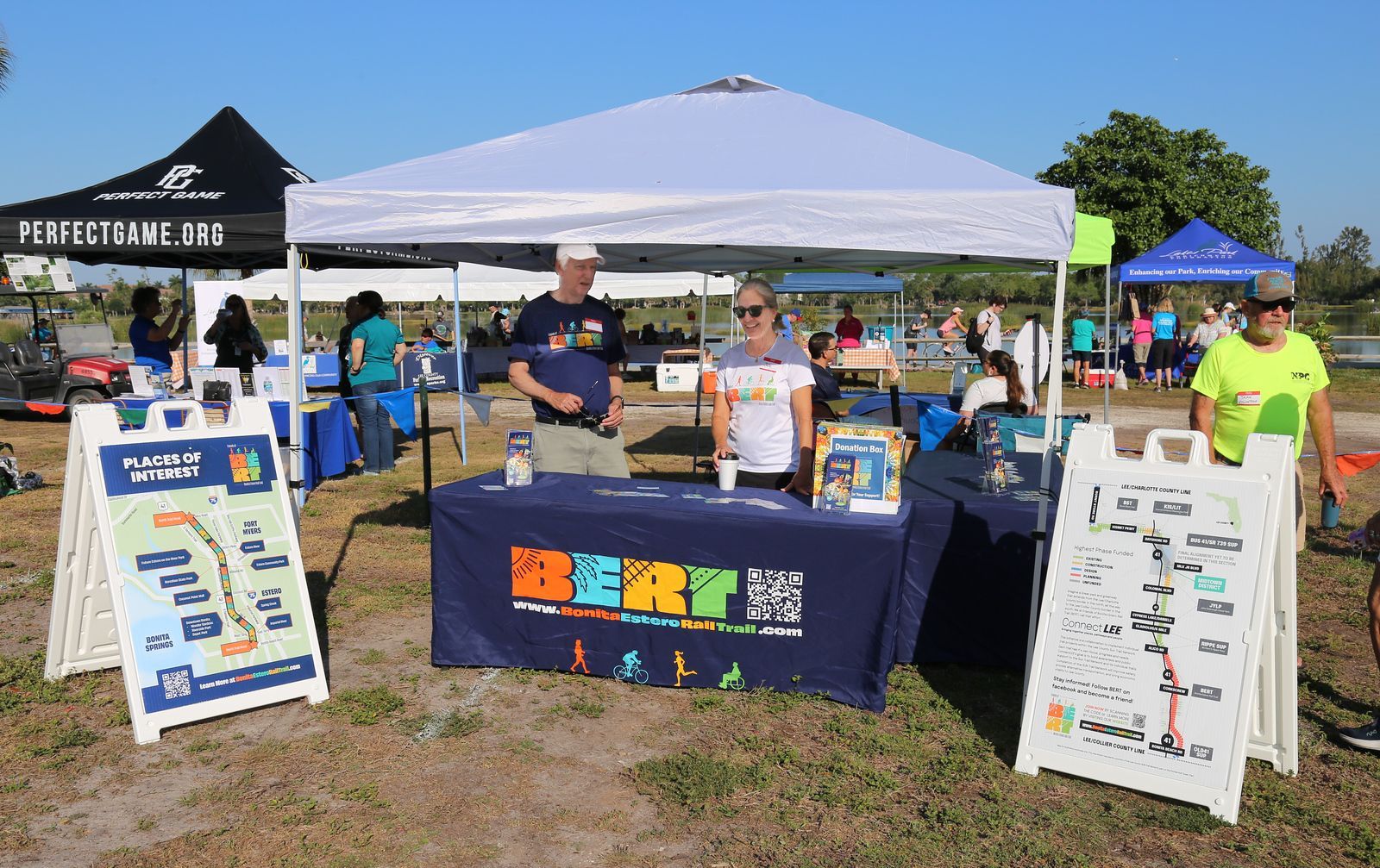 A group of people are standing around a table with a sign that says berry on it.