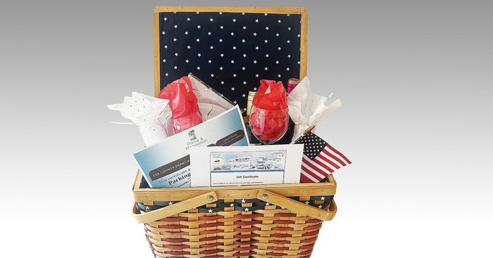 A cardboard box filled with candles , flowers , and a bookmark.