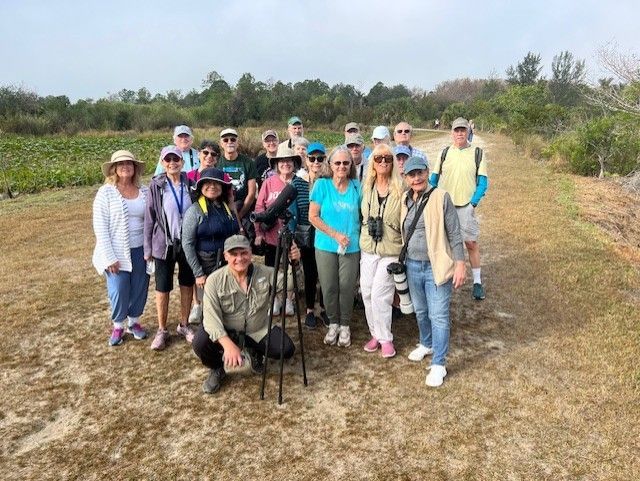 A group of people are posing for a picture in a field.
