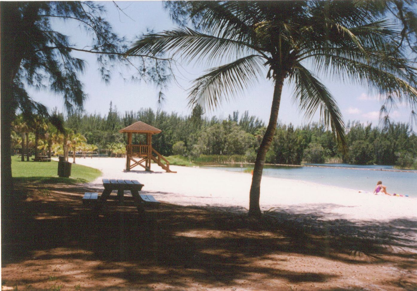 A beach with a picnic table and a lifeguard tower