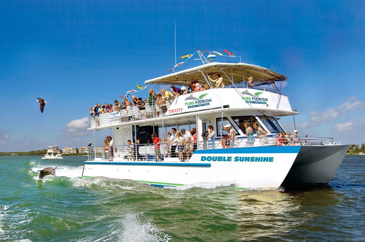 A boat filled with people is floating on top of a body of water.