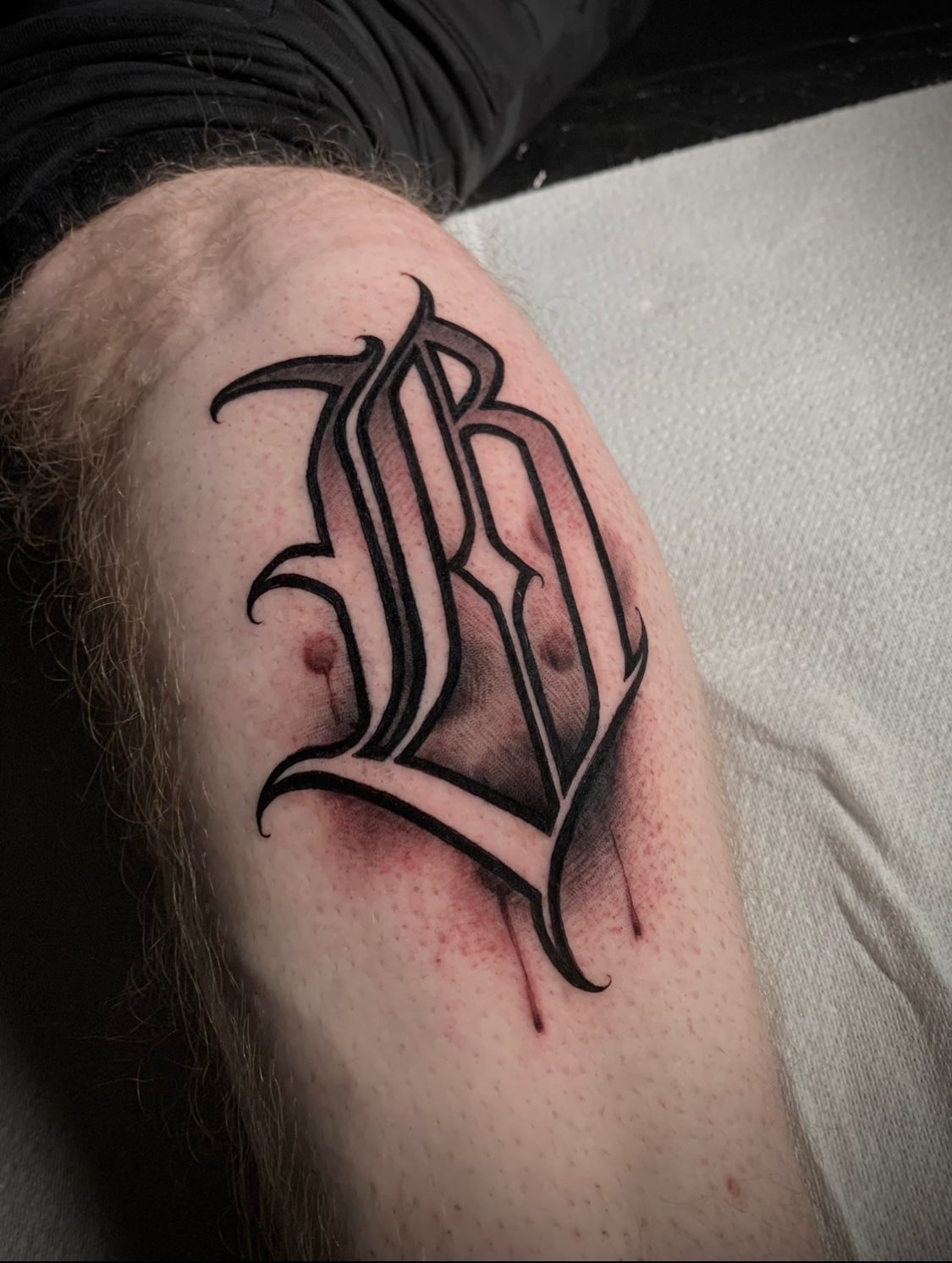 Tattoo of a gothic-style letter 