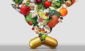 Various fruits and vegetables pouring into a capsule, symbolizing health supplements.