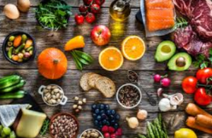 Assortment of fresh fruits, vegetables, and protein sources arranged on a wooden table, emphasizing healthy eating.