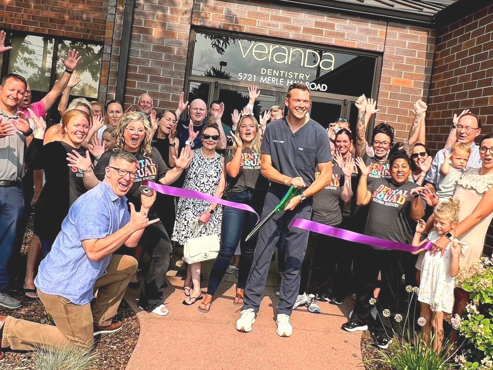 Group of people celebrating a ribbon-cutting event at
