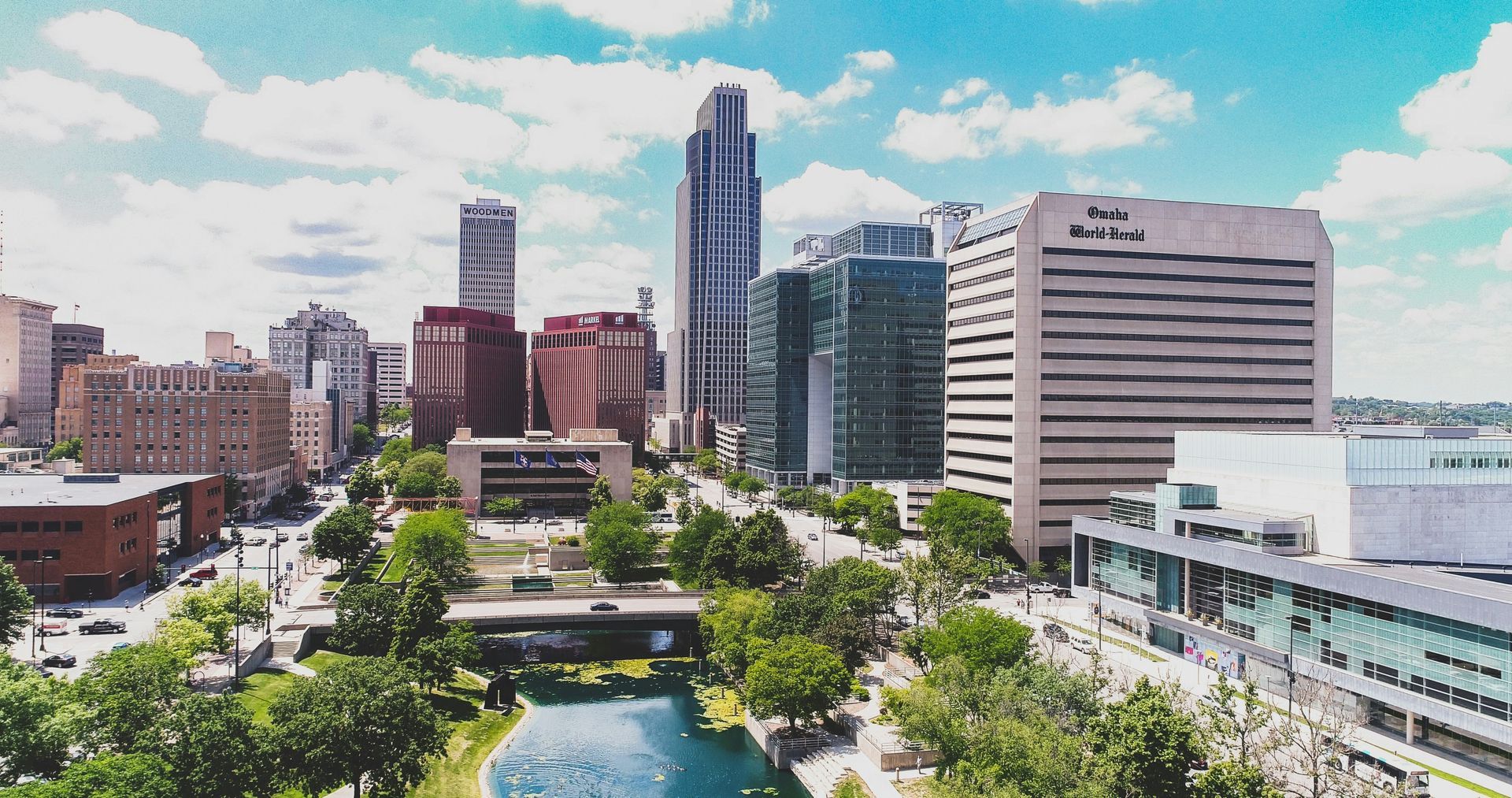 An aerial view of a city skyline with a river in the foreground.