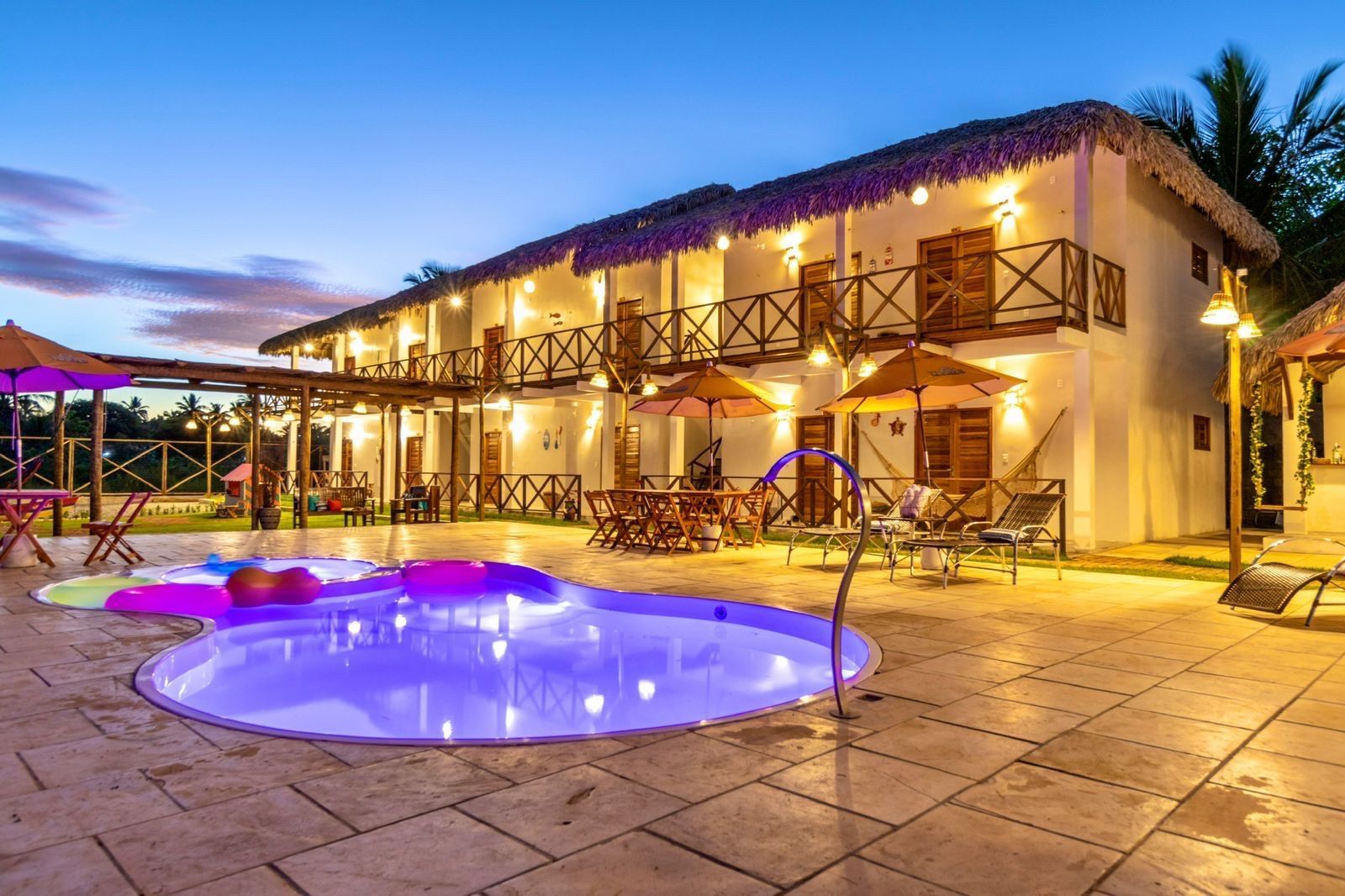 Um grande edifício branco com uma piscina na frente.