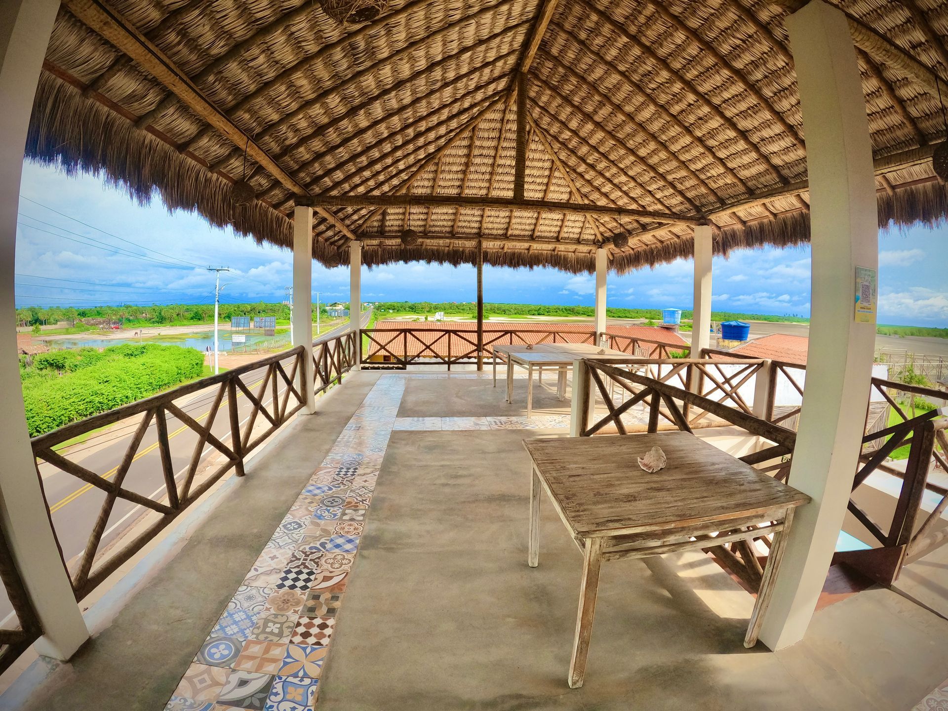 Um mirante com telhado de palha e uma mesa embaixo
