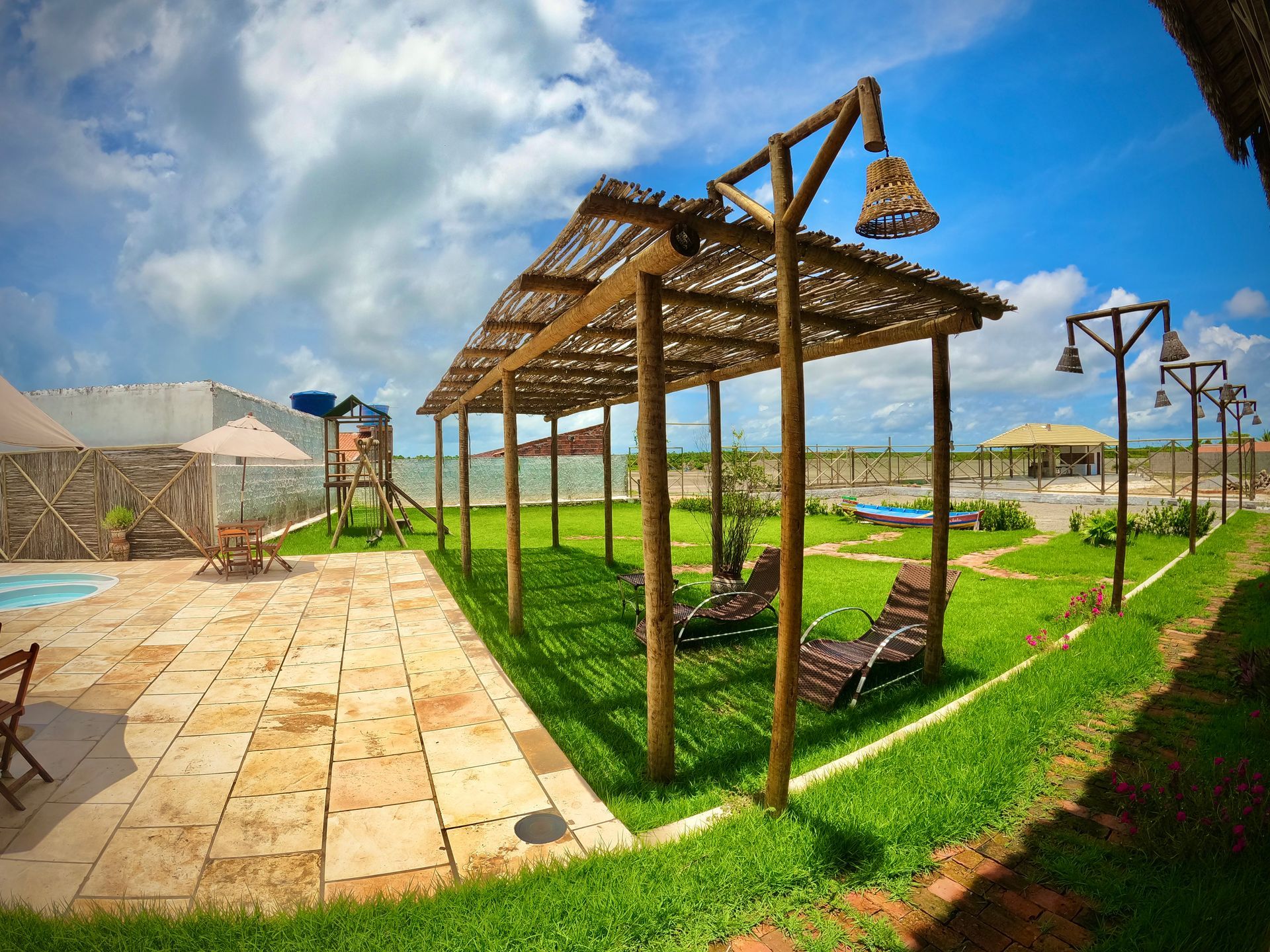 Uma piscina com uma pérgola e cadeiras na frente dela