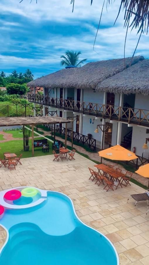 Uma vista aérea de um hotel com piscina e guarda-sóis.
