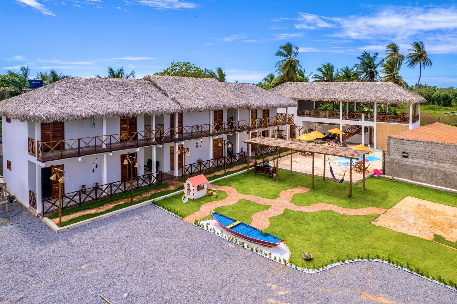 Uma vista aérea de um hotel com um barco na frente.