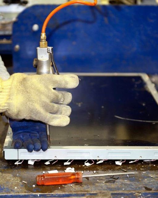 A person wearing gloves is working on a piece of metal.