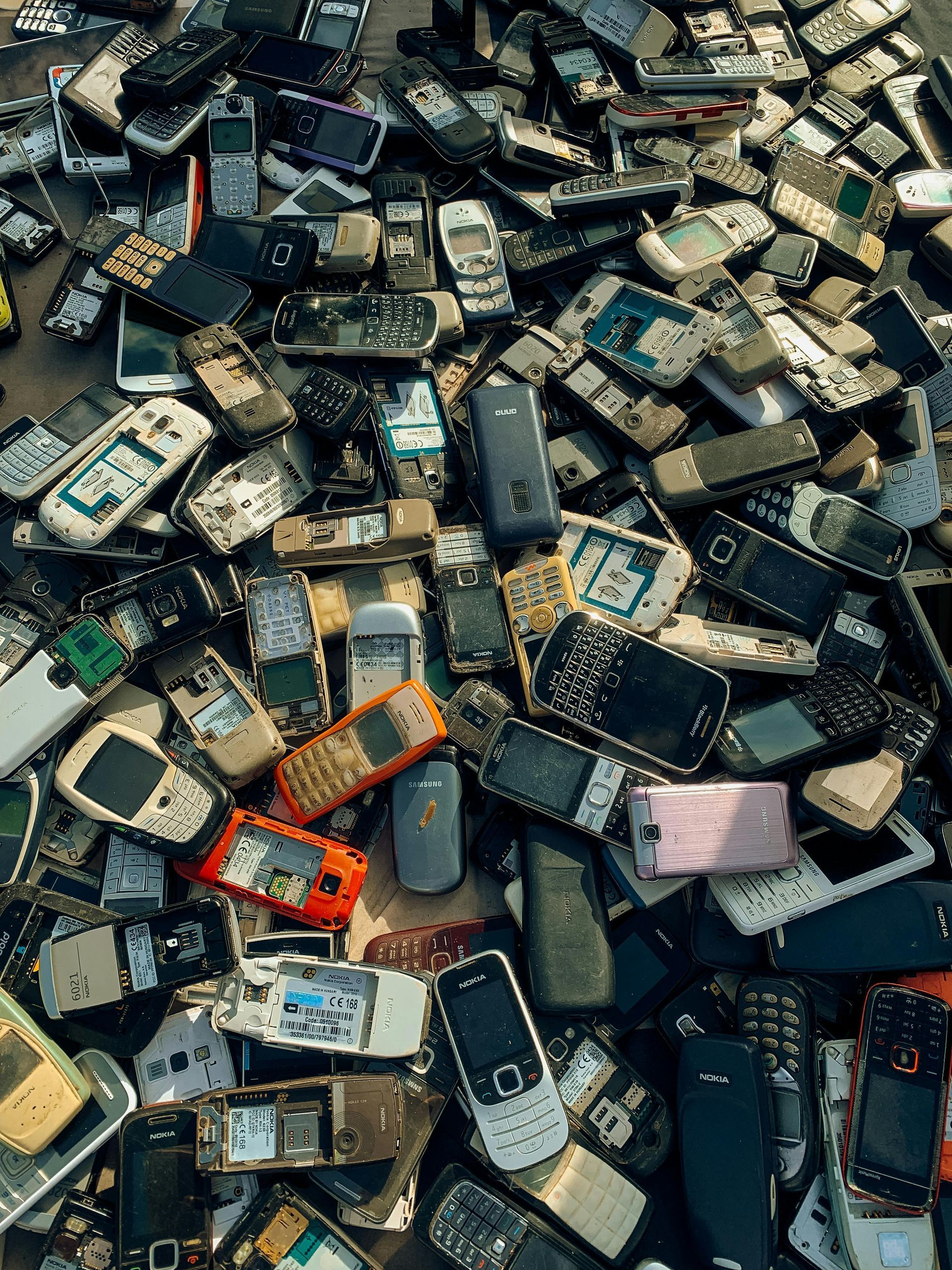 A pile of old cell phones on a table