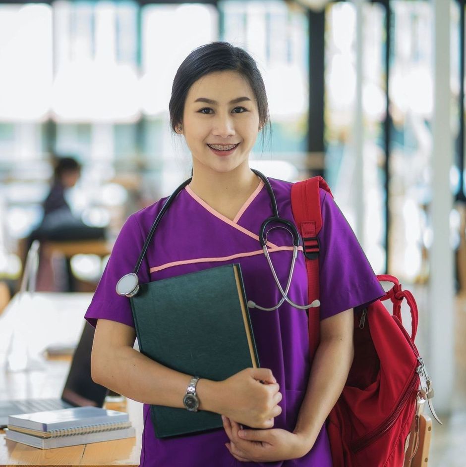 hopeful female nursing student holding NCLEX study materials