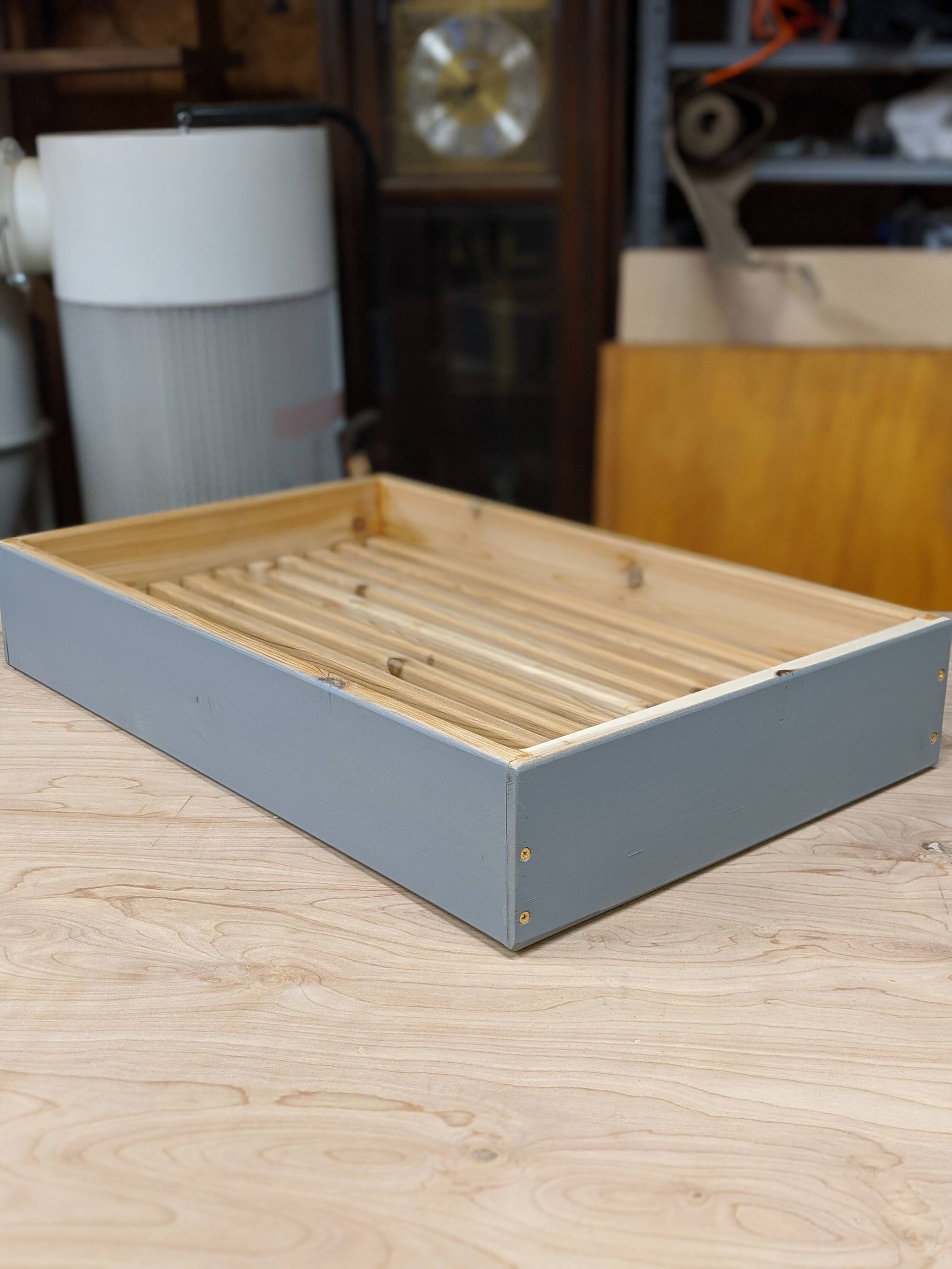 A wooden tray is sitting on a wooden table.