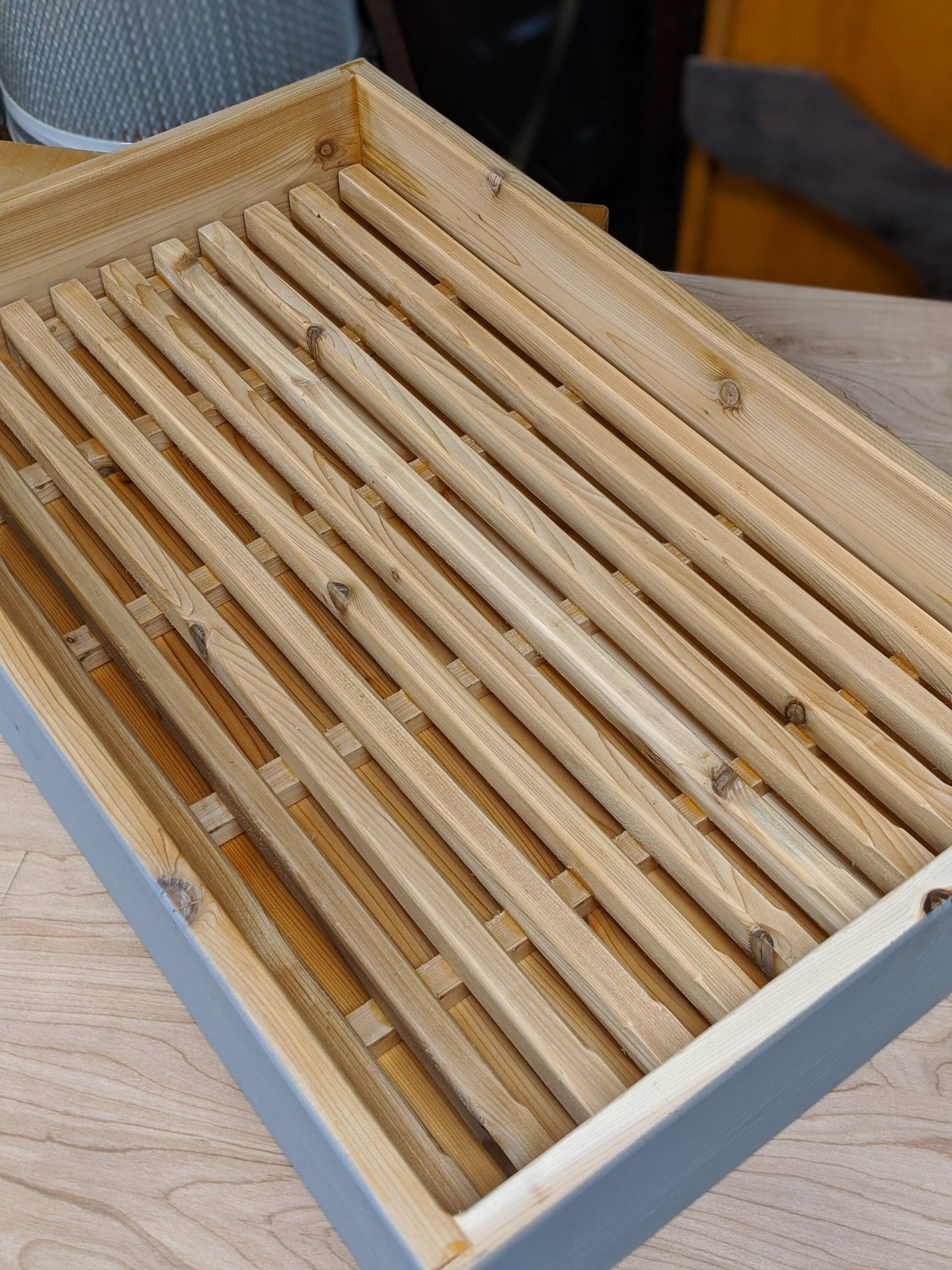 A wooden tray is sitting on a wooden table.