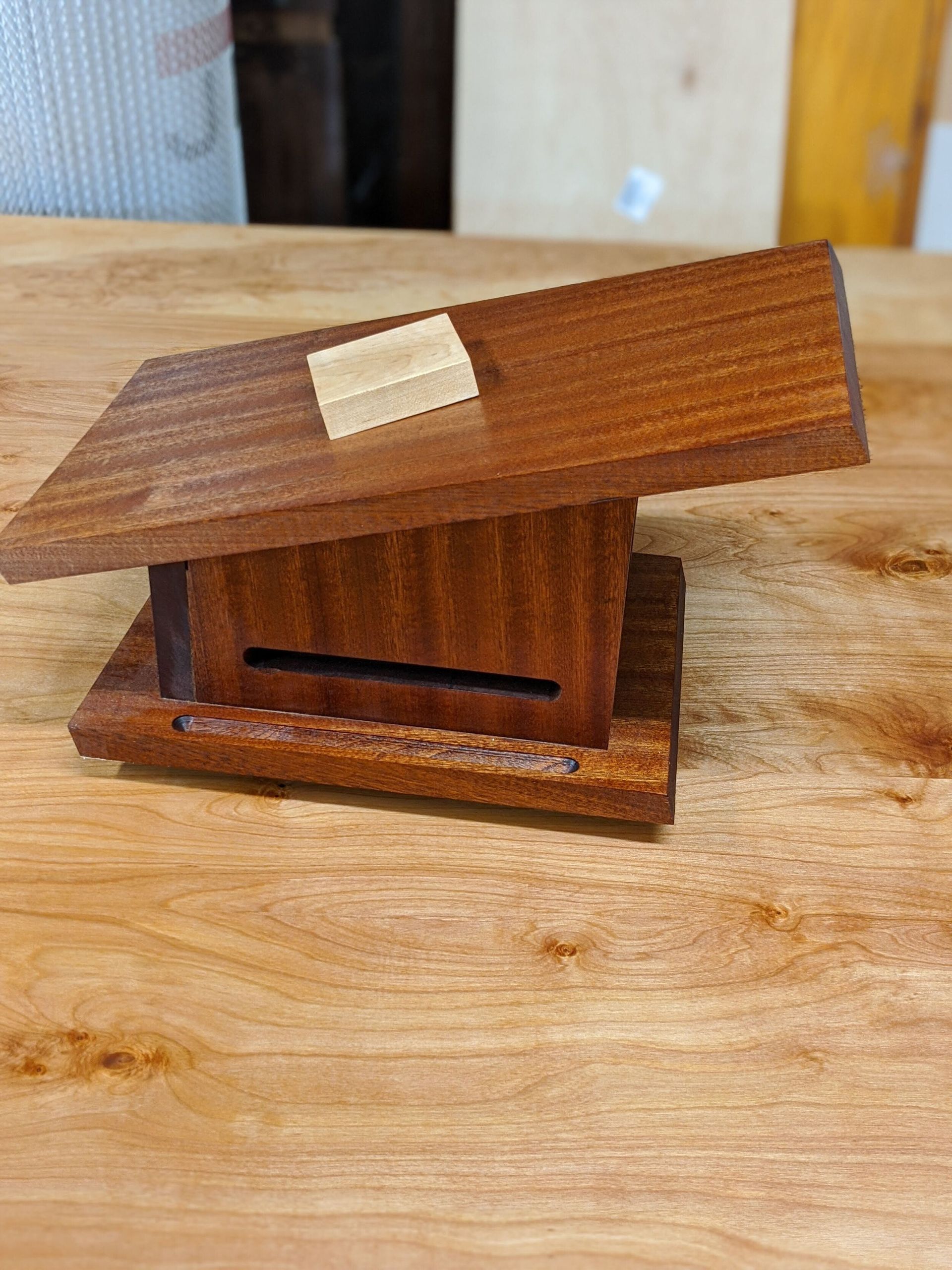 A small wooden house is sitting on top of a wooden table.