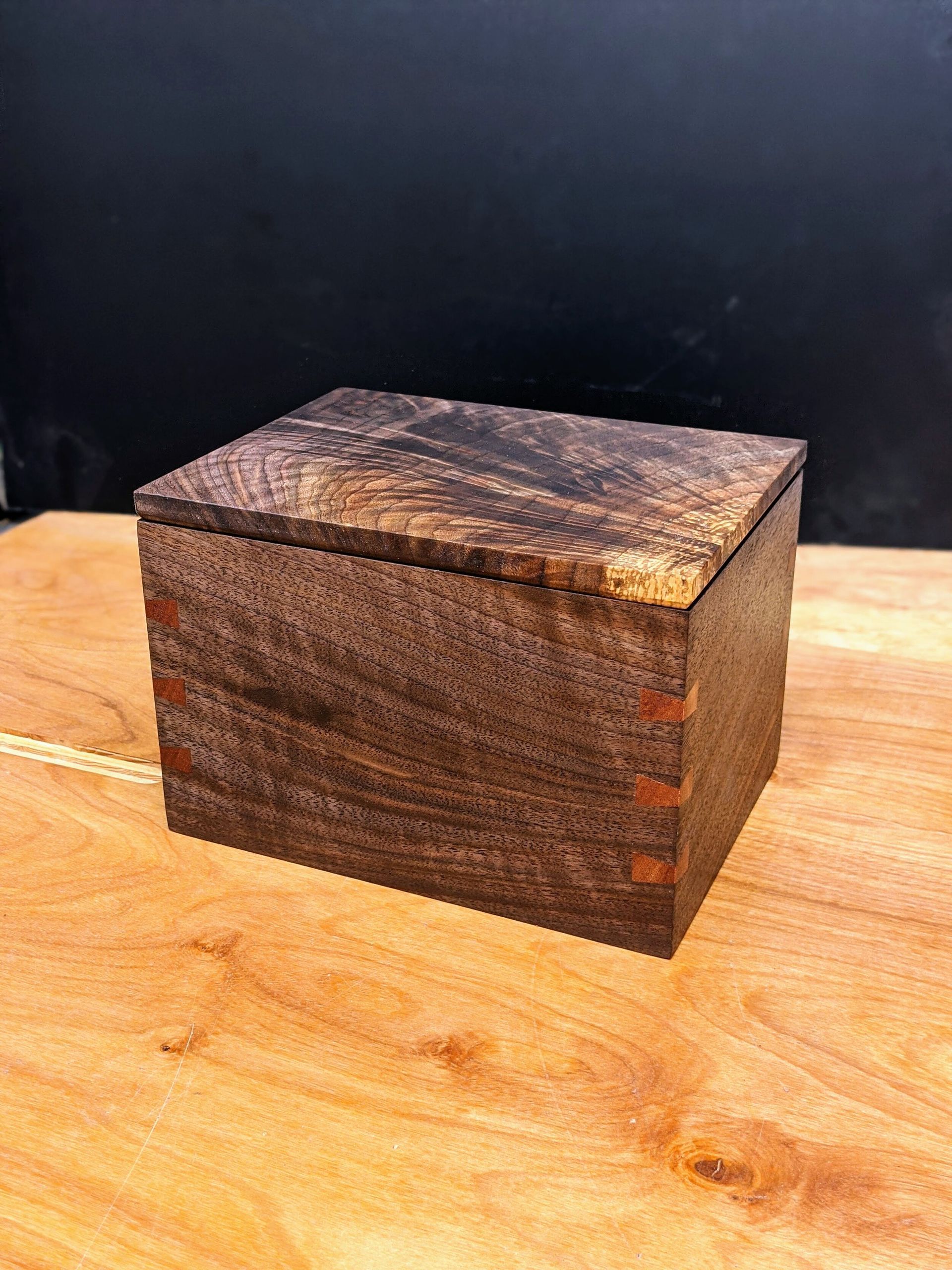 A small wooden box is sitting on top of a wooden table.
