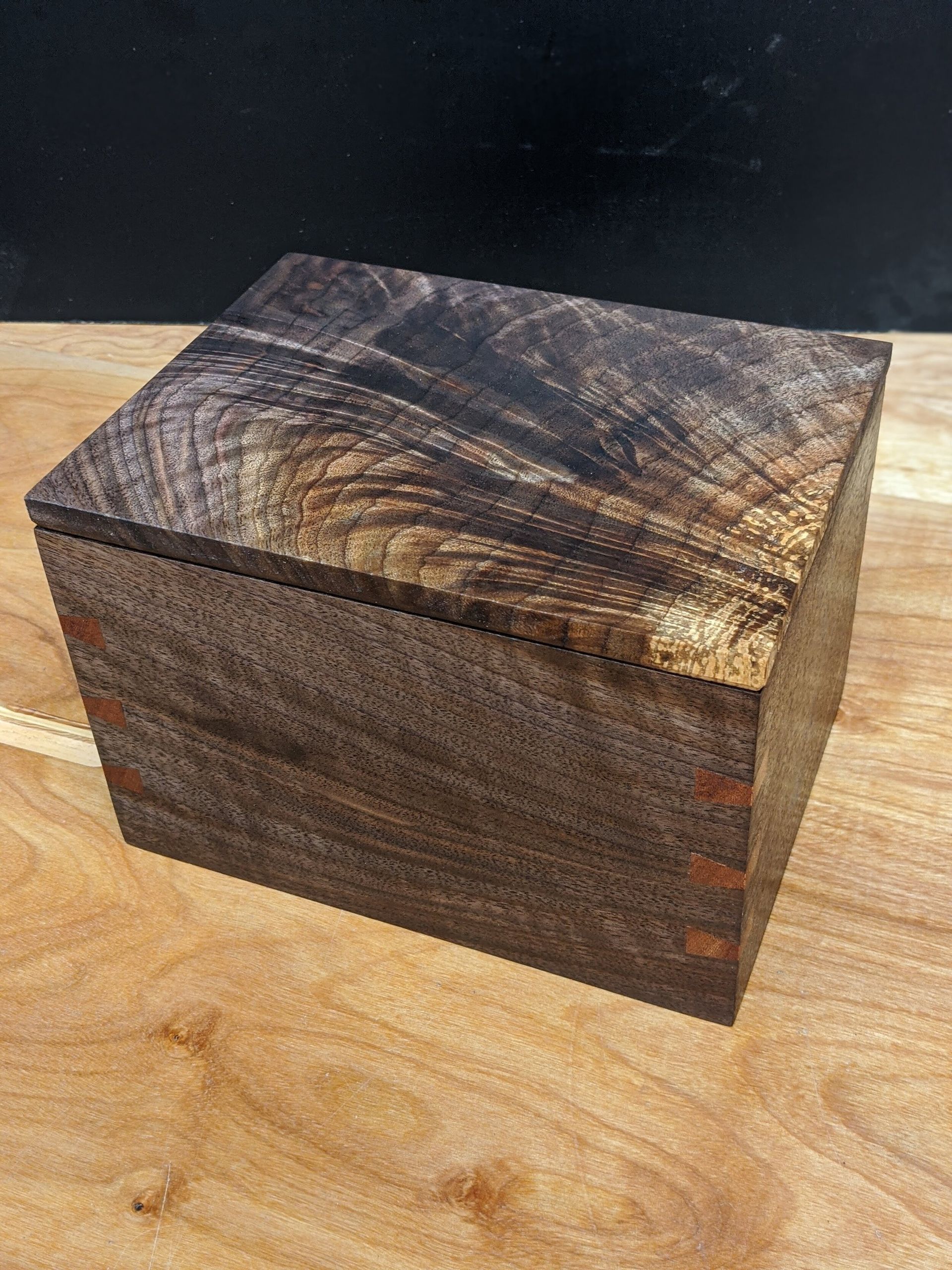 A small wooden box is sitting on top of a wooden table.