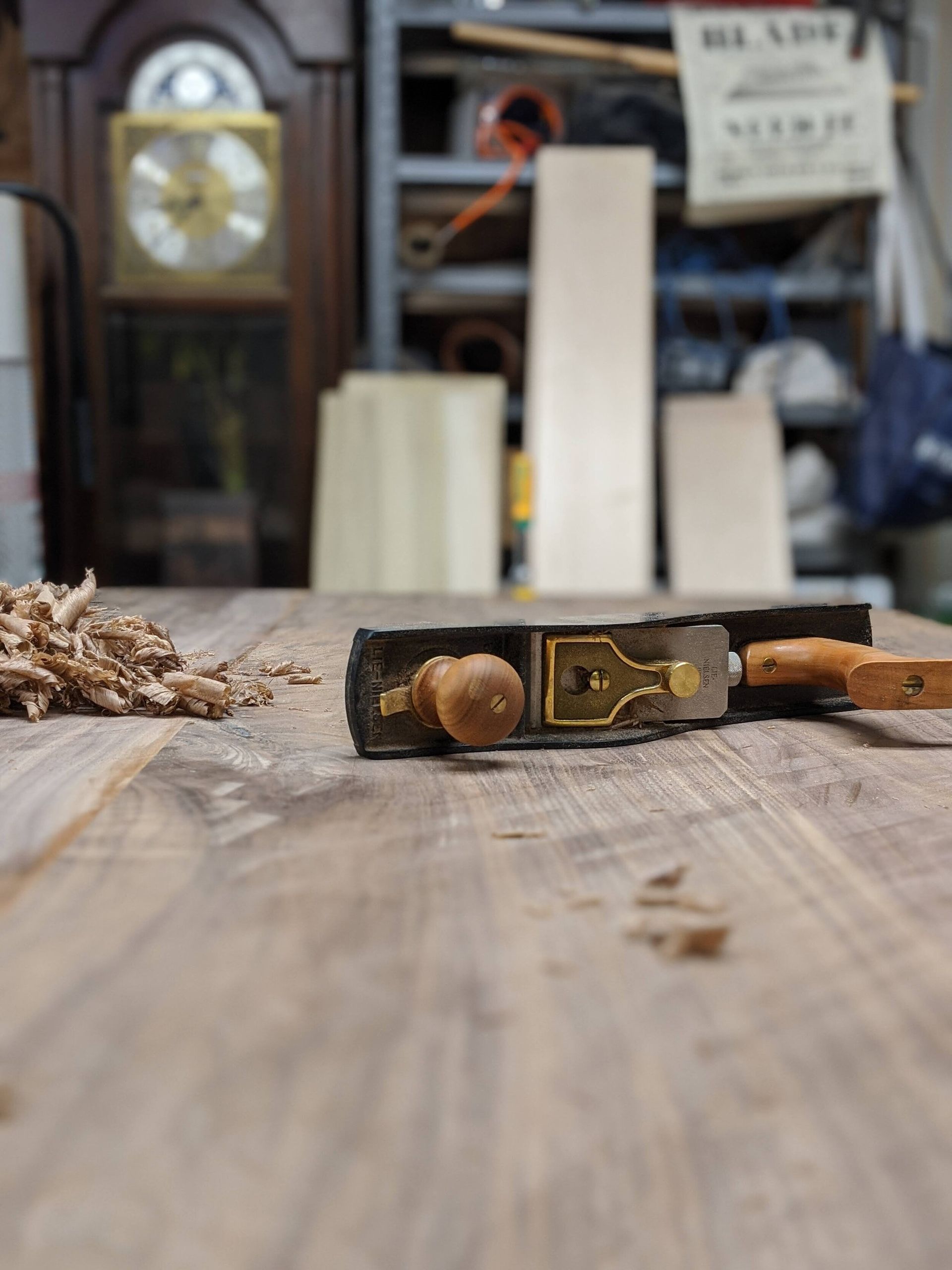 A plane is laying on a wooden table with a clock in the background