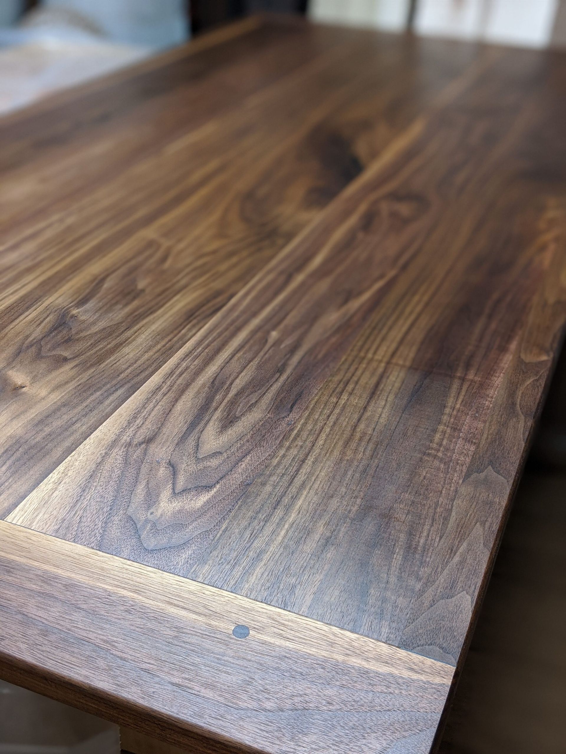 A close up of a wooden table top in a room.