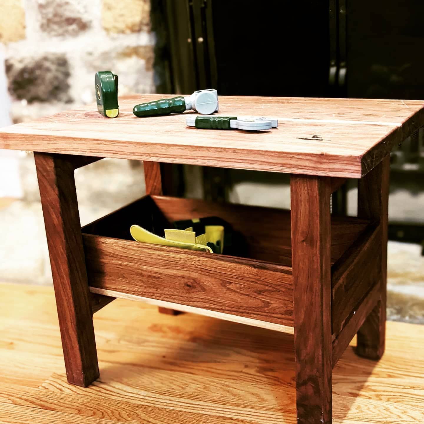 A small wooden table with a tray underneath it