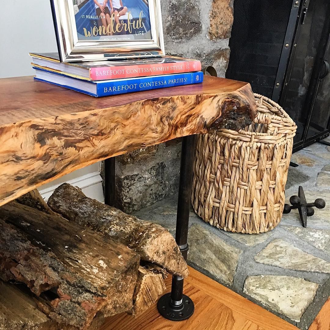 A wooden table with books and a picture frame on top of it.