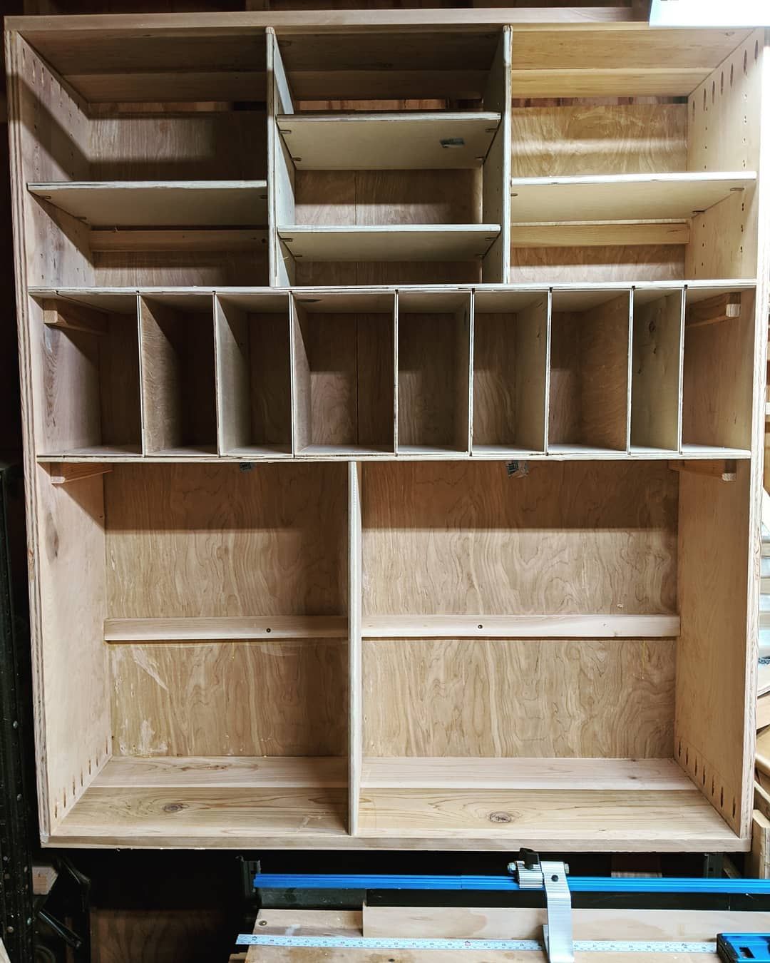 A wooden shelf with lots of shelves is sitting on top of a table.