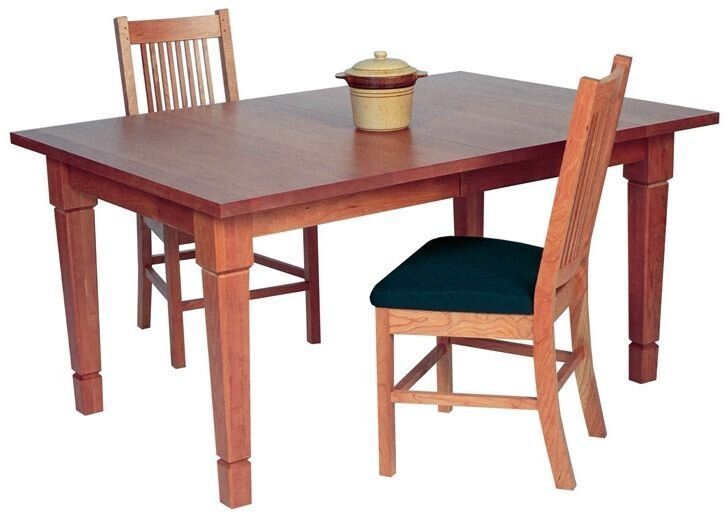 A wooden table with two chairs and a pot on it