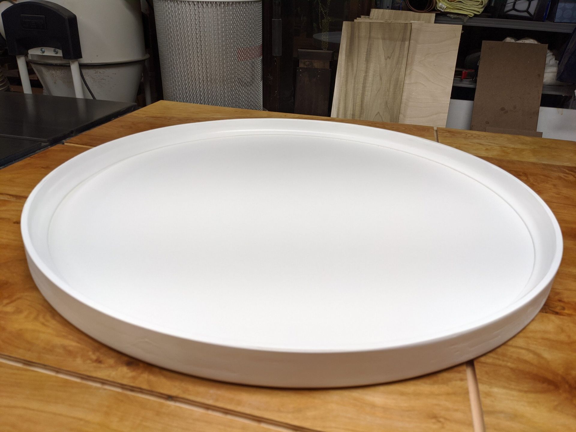 A large white plate is sitting on a wooden table.