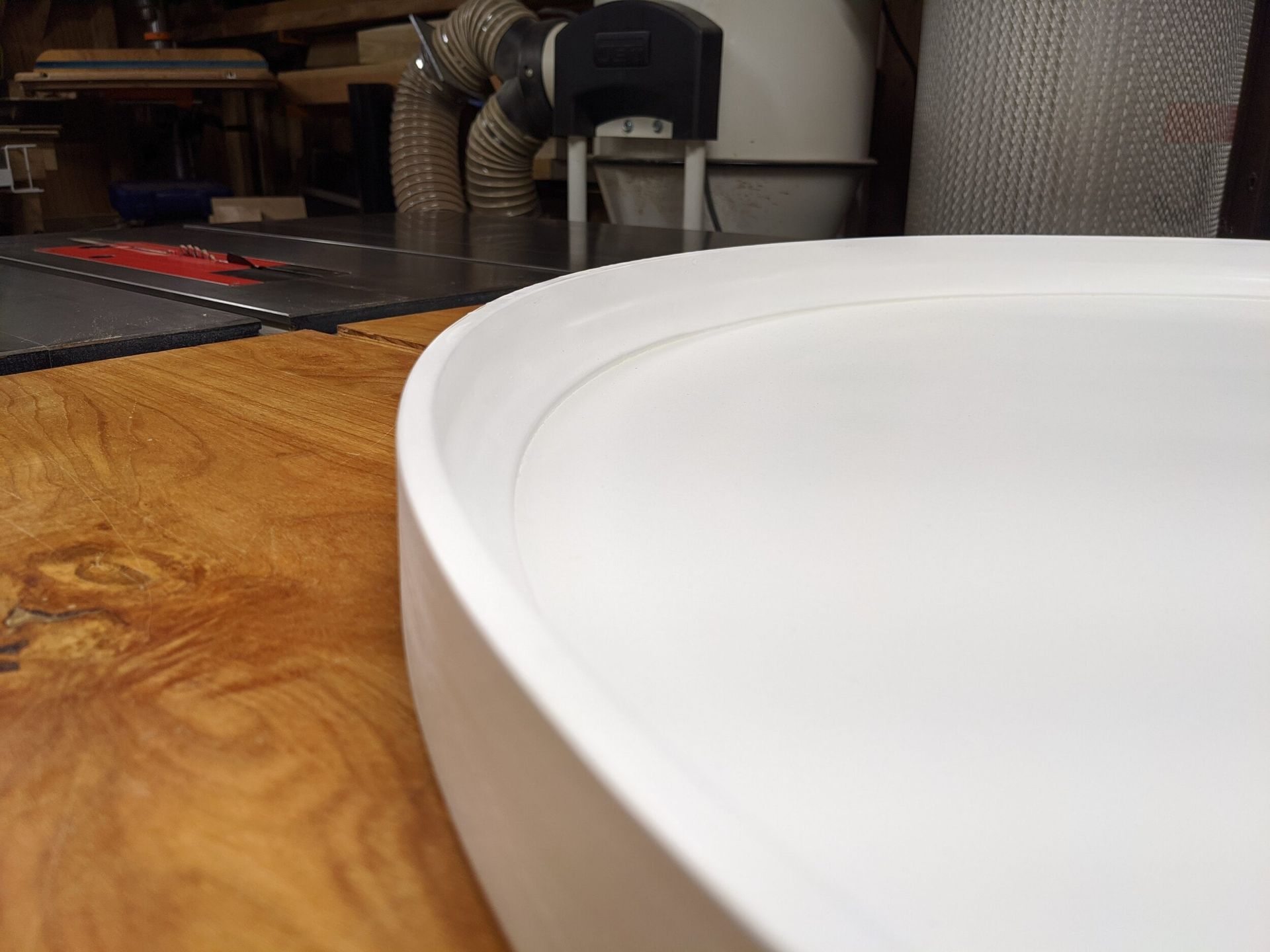 A white bowl is sitting on a wooden table