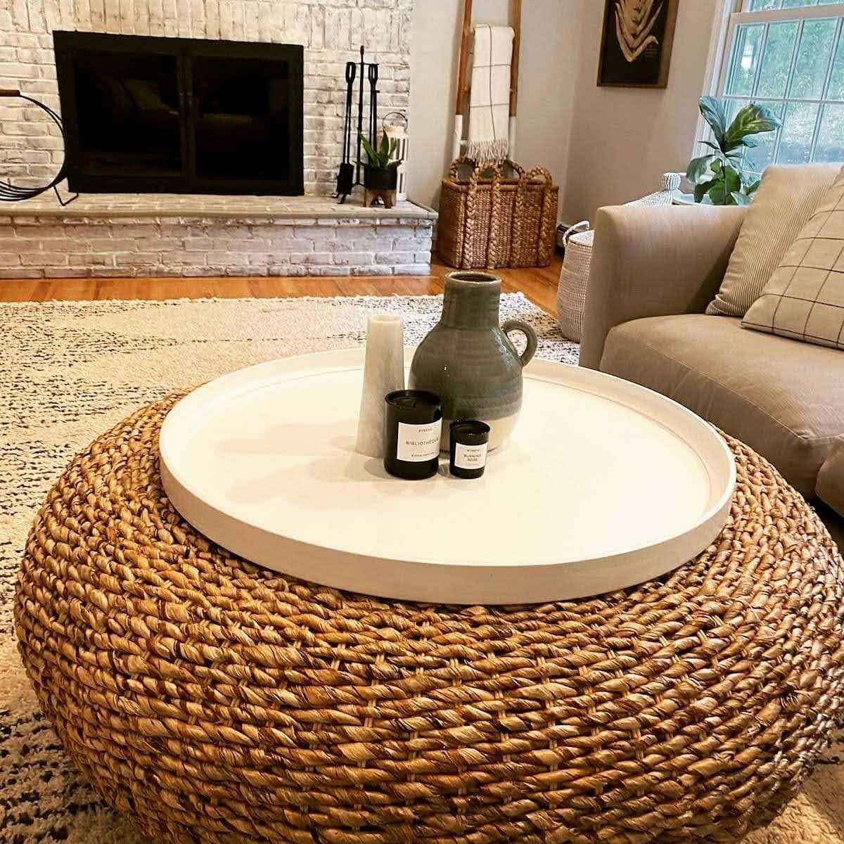 A living room with a wicker coffee table and a fireplace.