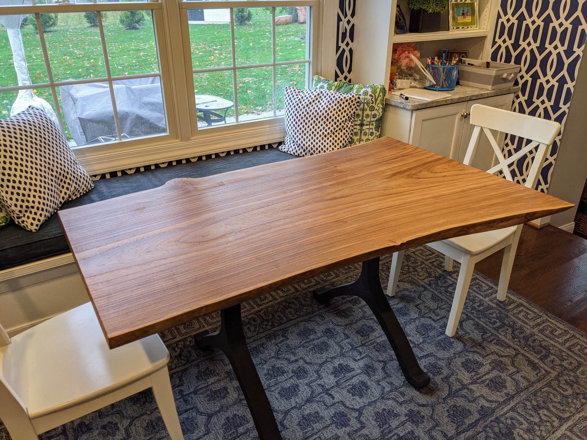 A wooden table is sitting in front of a window in a room.