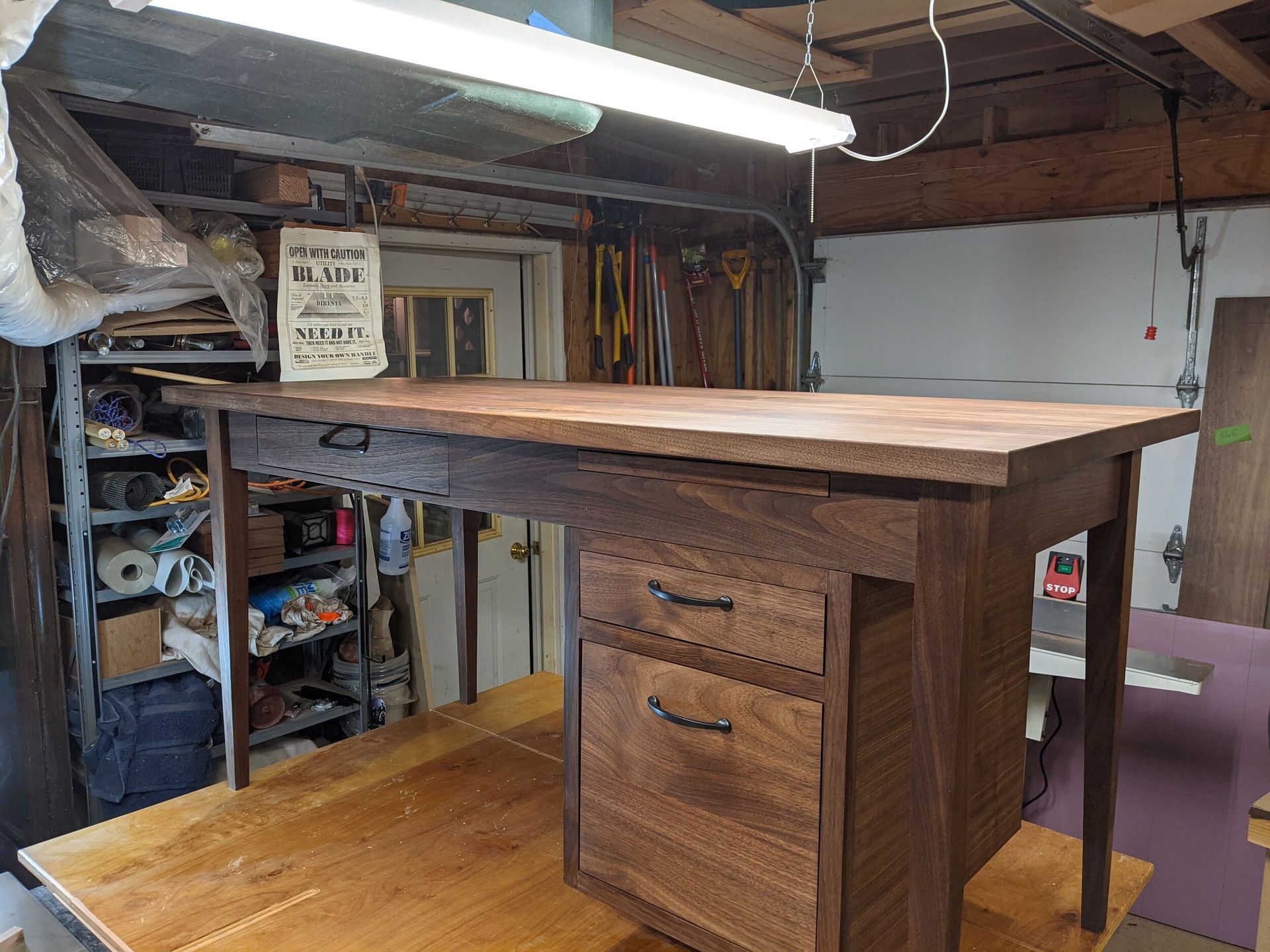 A wooden desk with drawers is sitting in a garage.