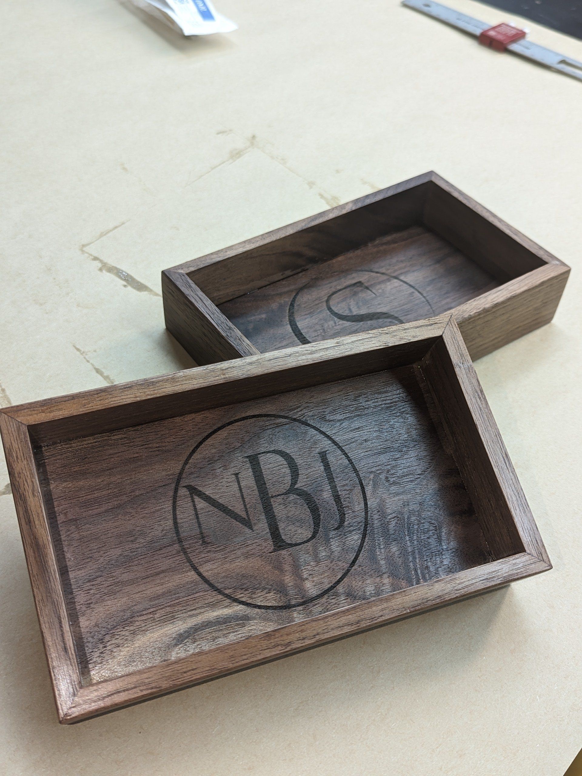 Two wooden trays with the letters nb engraved on them