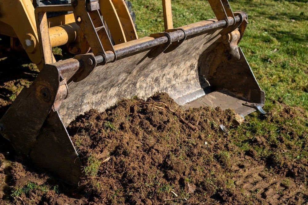 A bulldozer is scooping dirt out of a field.