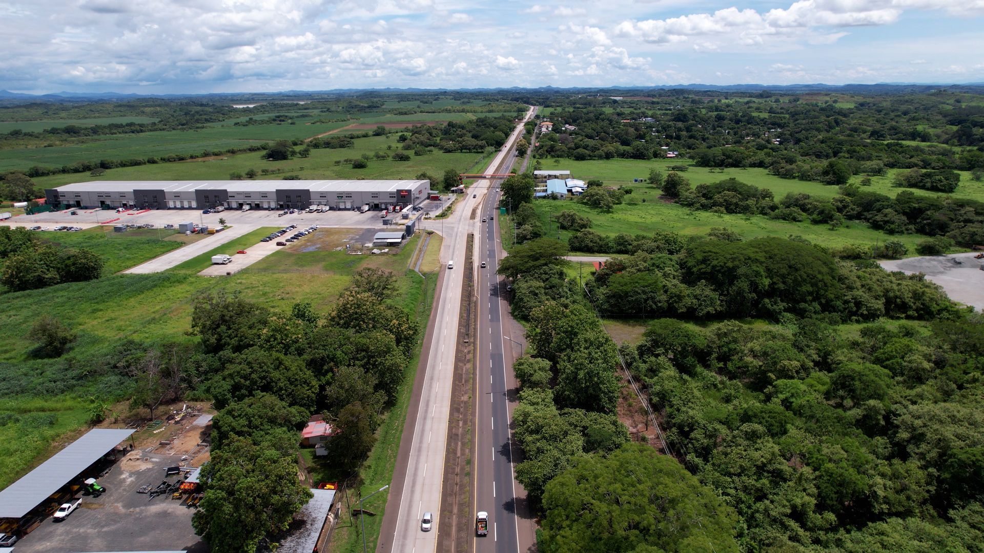 Una vista aérea de una carretera rodeada de árboles y campos.